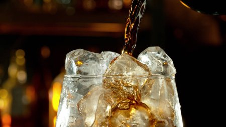 Foto de Super macro toma de verter la bebida de cola en el vaso. Cubos de hielo dentro
. - Imagen libre de derechos