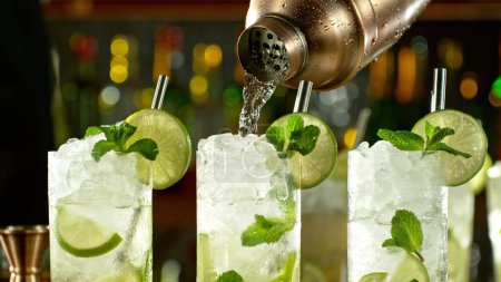 Téléchargez les photos : Preparation of mojito drinks on bar counter. Fresh beverages background. - en image libre de droit