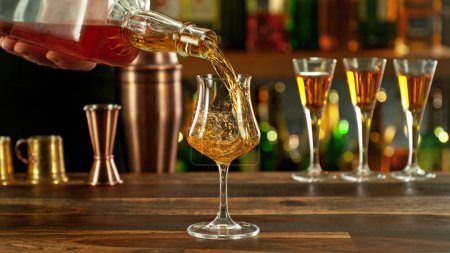 Téléchargez les photos : Detail of pouring rum into glass. Bar on background. - en image libre de droit