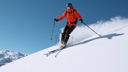 Foto de Free ride skier running down the hill. Powder snow is flying up in the air. - Imagen libre de derechos