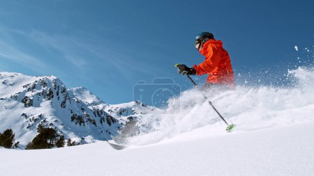 Foto de Free ride skier running down the hill. Powder snow is flying up in the air. - Imagen libre de derechos