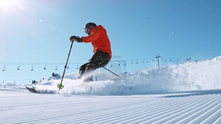 Photo for Alpine skier running down the hill. Powder snow is flying up in the air. - Royalty Free Image