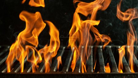Foto de Parrilla de barbacoa con llamas de fuego. Rejilla de fuego vacía sobre fondo negro. - Imagen libre de derechos