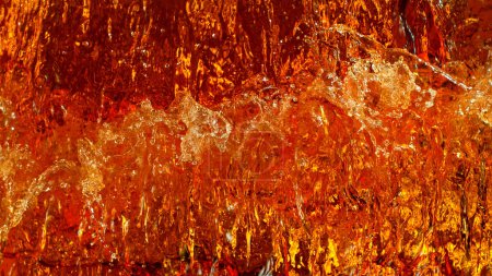 Foto de Liquid golden splash texture, abstract beverages background. Whisky, rum, cognac, tea or oil. - Imagen libre de derechos