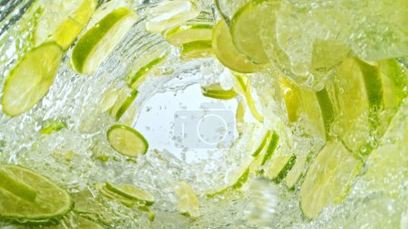 Photo for Texture of splashing water with lime slices. Abstract beverage background, freeze motion. - Royalty Free Image