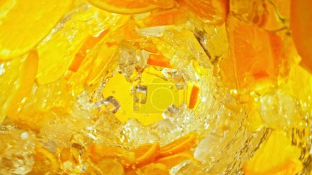 Foto de Textura de agua salpicada con rodajas de naranja. Fondo abstracto de la bebida, movimiento de congelación. - Imagen libre de derechos