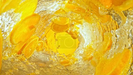 Foto de Textura de agua salpicada con rodajas de naranja. Fondo abstracto de la bebida, movimiento de congelación. - Imagen libre de derechos