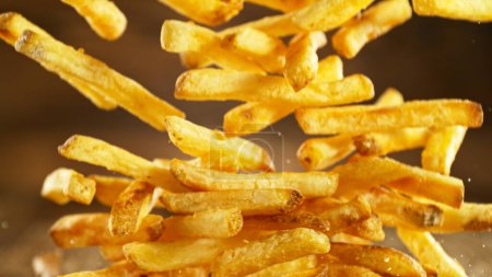 Photo for French fries - fried potatoes hitting the table. Fast food meal in freeze motion. - Royalty Free Image