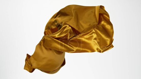 Foto de Paño de raso dorado elegante liso separado sobre fondo blanco. Textura de tela voladora, movimiento de congelación. - Imagen libre de derechos