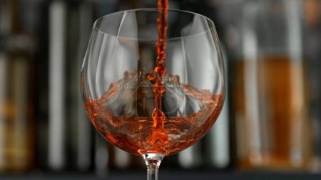 Téléchargez les photos : Verser du vin rouge dans du verre sur fond sombre. Boissons Contexte. - en image libre de droit