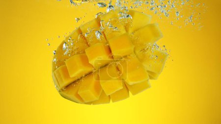 Téléchargez les photos : Fruits de mangue frais sous l'eau, isolés sur fond coloré. - en image libre de droit