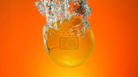Photo for Fresh Whole Orange Underwater, Isolated on Coloured Background. - Royalty Free Image