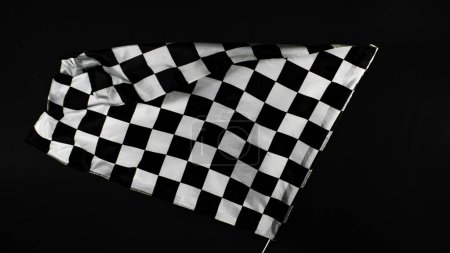 Foto de Bandera de carreras contrastada contra fondo negro. Tiro de estudio. - Imagen libre de derechos