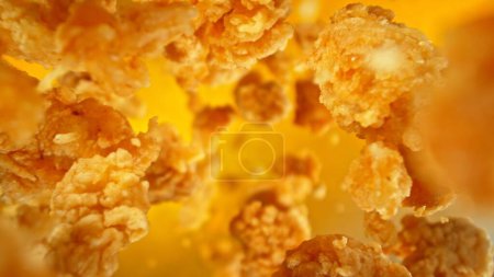 Photo for Freeze motion of flying pieces of fried chicken pieces on colored background. Concept of levitating food. - Royalty Free Image