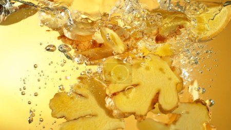 Photo for Freeze Motion of Ginger Slices Falling into Water. Fresh Spice in water. - Royalty Free Image