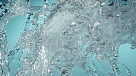 Téléchargez les photos : Freeze Motion of Water Splash in Closeup. Isolé sur fond bleu. - en image libre de droit