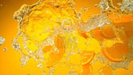 Photo for Freeze Motion of Flying Slices of Oranges with Splashing Water. Isolated on Colored Background, closeup. - Royalty Free Image