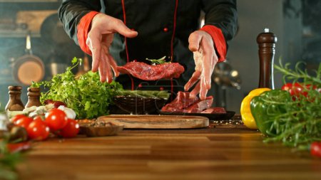 Photo for Chef Throwing Raw Beef Steak on Wooden Cutting Board. Preparation of Meat, Ingredients Around. - Royalty Free Image