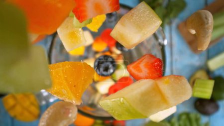 Téléchargez les photos : Chute de morceaux de fruits et légumes dans le mélangeur. Préparation de boisson Smoothie, vue sur le dessus Composition. - en image libre de droit