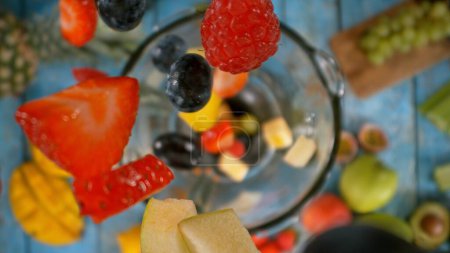 Téléchargez les photos : Chute de morceaux de fruits dans le mélangeur. Préparation de boisson Smoothie, vue sur le dessus Composition. - en image libre de droit