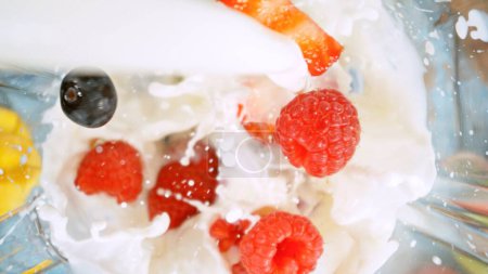 Foto de Overhead Shot of Pieces of Fruits with Milk in Blender. Preparación de Smoothie Drink, top Ver Composición. - Imagen libre de derechos