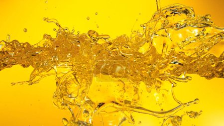 Foto de Aceite de girasol salpicando sobre fondo dorado. Captura de estudio, forma abstracta. - Imagen libre de derechos