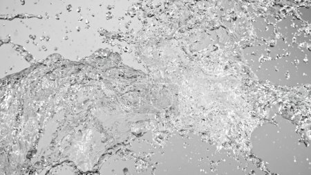 Foto de Salpicaduras de agua volando en el aire sobre fondo blanco. Congelar el movimiento de salpicaduras de agua realistas. - Imagen libre de derechos