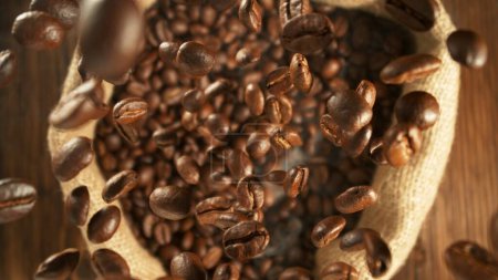 Foto de Congelar el movimiento de los granos de café volando en saco de yute. Disparo aéreo. - Imagen libre de derechos