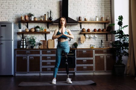 Photo for Woman with leg prosthesis performs yoga pose exuding confidence. Lady with disability finds solace and balance in yoga practice showing inner strength - Royalty Free Image