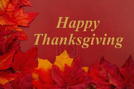 Foto de Feliz mensaje de Acción de Gracias con hojas de otoño de color naranja sobre madera roja - Imagen libre de derechos