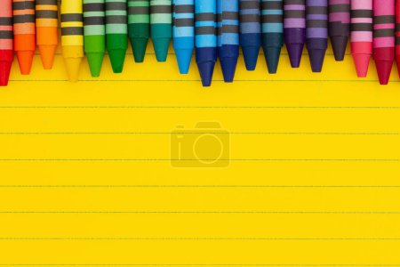 Foto de Papel de cuaderno de línea gobernado amarillo brillante con fondo de lápices de colores para usted educación o mensaje escolar - Imagen libre de derechos