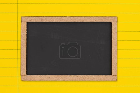 Foto de Pizarra en blanco sobre fondo de papel de cuaderno de línea gobernada de color amarillo brillante para usted educación o mensaje escolar - Imagen libre de derechos