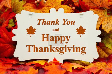Foto de Gracias y feliz saludo de Acción de Gracias en la señal y hojas de otoño - Imagen libre de derechos
