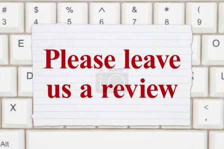Photo for Please leave us a review lined paper on a keyboard - Royalty Free Image
