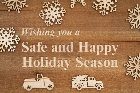 Foto de Mensaje de temporada festiva segura y feliz con copos de nieve de madera y camiones retro en madera envejecida - Imagen libre de derechos
