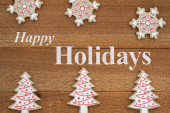 Happy Holidays greeting with wood snowflakes and trees on weathered brown wood Poster #625474556