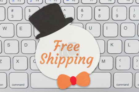 Photo for Free Shipping message on a red Christmas snowman gift tag on a keyboard for your holiday online shopping message - Royalty Free Image