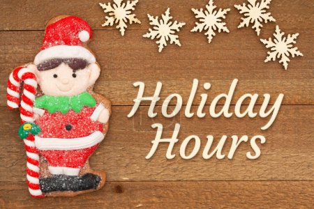 Holiday Hours message with cute gingerbread elf on weathered wood with snowflakes