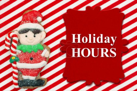 Téléchargez les photos : Vacances Heures message avec mignon elfe en pain d'épice sur matériel rayé rouge et blanc - en image libre de droit