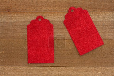 Téléchargez les photos : Étiquette cadeau rouge vierge sur bois altéré pour votre message de magasinage des Fêtes - en image libre de droit