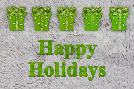 Téléchargez les photos : Joyeuses fêtes de vœux avec cadeaux verts de Noël sur matière grise en peluche - en image libre de droit