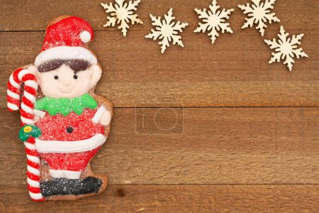 Téléchargez les photos : Joli elfe en pain d'épice sur fond de vacances en bois altéré pour votre message d'hiver ou de saison - en image libre de droit
