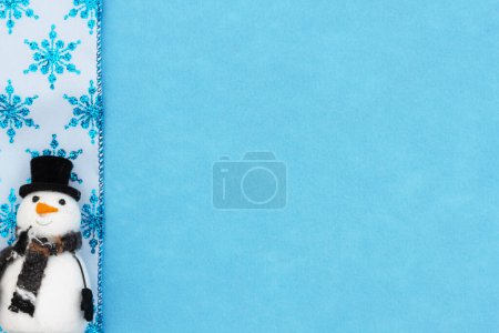 Téléchargez les photos : Bonhomme de neige et flocons de neige bleus sur fond de vacances en feutre pour votre message d'hiver ou saisonnier - en image libre de droit
