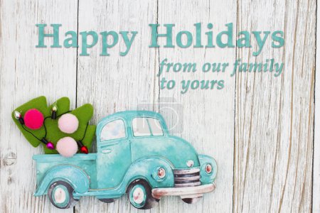 Téléchargez les photos : Joyeuses vacances de notre famille à la vôtre avec camion rétro avec arbre de Noël sur bois altéré - en image libre de droit