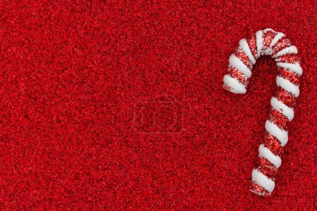 Téléchargez les photos : Canne à bonbons sur papier paillettes rouge fond de vacances pour votre message d'hiver ou saisonnier - en image libre de droit