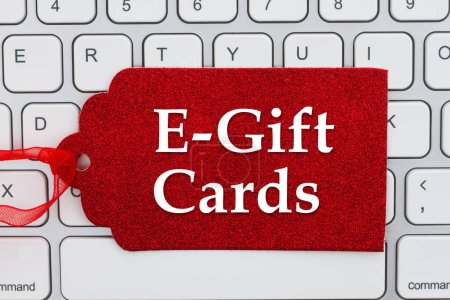 Téléchargez les photos : E-gift Cards message on red gift tag on a keyboard for your holiday online shopping message - en image libre de droit