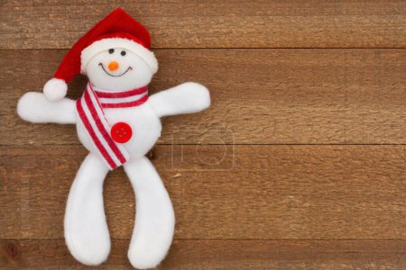 Téléchargez les photos : Bonhomme de neige mignon Santa sur fond de vacances en bois altéré pour votre message d'hiver ou saisonnier - en image libre de droit