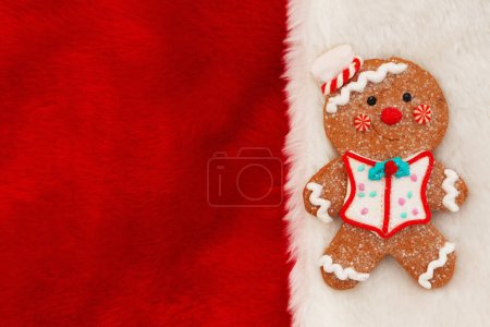Téléchargez les photos : Mignon homme de pain d'épice sur fond de vacances en peluche rouge pour votre message d'hiver ou saisonnier - en image libre de droit