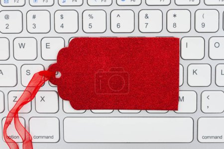 Photo for Blank red gift tag on a keyboard for your holiday online shopping message - Royalty Free Image