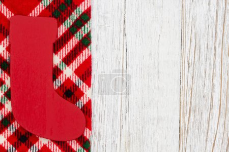 Photo for Christmas stocking on buffalo plaid border material holiday background on weathered wood for your winter or seasonal message - Royalty Free Image